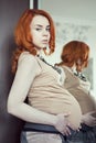 Red-haired pregnant woman in high-heeled shoes and fashionable personal clothes Royalty Free Stock Photo