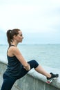 Red-haired, pretty girl in freckles on the sea beach engaged in sports, gymnastics. Outdoor sports Royalty Free Stock Photo