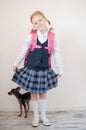Schoolgirl with a pink briefcase and dog indoors