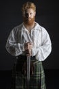 Red-haired Scotsman posing with a sword
