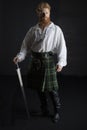 Red-haired Scotsman posing with a sword