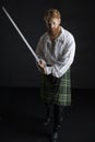 Red-haired Scotsman posing with a sword