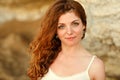 The red-haired sensual girl with freckles on a background of yellow rocks at sunset in summer Royalty Free Stock Photo