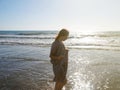 Red-haired teen girl in a long dress on the seashore in the sun Royalty Free Stock Photo