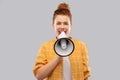 Red haired teenage girl speaking to megaphone Royalty Free Stock Photo