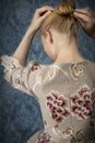 Red-haired 18th century woman standing in front of baroque wall paper Royalty Free Stock Photo