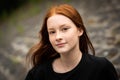 Red haired twelve year old girl with freckles posing with a city bokeh background Royalty Free Stock Photo