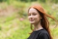 Red haired twelve year old girl with freckles posing with a nature bokeh background Royalty Free Stock Photo