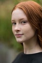 Red haired twelve year old girl with freckles posing with a nature bokeh background Royalty Free Stock Photo