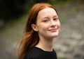 Red haired twelve year old girl with freckles posing with a nature bokeh background Royalty Free Stock Photo