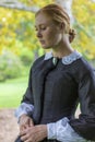 Victorian woman in black dress walking in garden Royalty Free Stock Photo