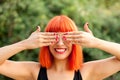 Red haired woman covering her eyes in a park Royalty Free Stock Photo