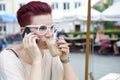 Red-haired woman drinking coffee and talking on the phone Royalty Free Stock Photo