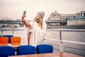 Red-haired woman in glasses traveler in a hat and jacket making a selfie in Moscow on a pleasure boat on the river in the center