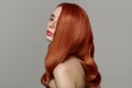 Red-haired woman on a gray background. Perfectly styled hair Royalty Free Stock Photo