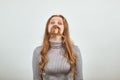 Red haired woman in gray sweater made her hair an imitation of man`s moustache Royalty Free Stock Photo
