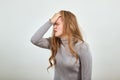 Red haired woman in gray sweater shows the emotion of grief trouble problems