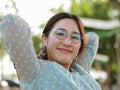 Red-haired woman in green shirt and eye care glasses sitting happy smiling looking outdoor Royalty Free Stock Photo