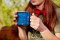 Woman holding metal mug