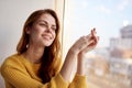 red-haired woman lies near the window dreamy look Royalty Free Stock Photo