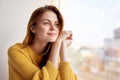 red-haired woman lies near the window dreamy look Royalty Free Stock Photo