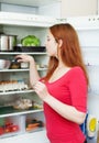 Red-haired woman looking for something in the fridge Royalty Free Stock Photo