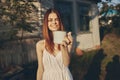 red-haired woman metal mug countryside