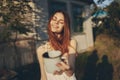 red-haired woman metal mug countryside