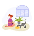 Red-haired woman sitting with coffee, cat eating from bowl indoors. Casual home life with pet, relaxation. Peaceful