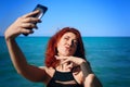 Red-haired woman takes selfie on smartphone camera. Royalty Free Stock Photo