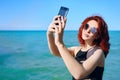 Red-haired woman takes selfie on smartphone camera Royalty Free Stock Photo