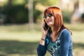 Red-haired woman talking on her cell phone and smiling. Royalty Free Stock Photo