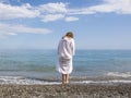 Red-haired woman in a white robe on the seashore Royalty Free Stock Photo