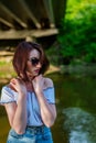 Red haired young girl wrapped in orange blanket posing near the swamp or lake with duckweed Royalty Free Stock Photo