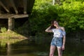 Red haired young girl wrapped in orange blanket posing near the swamp or lake with duckweed Royalty Free Stock Photo