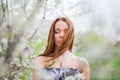 Red-haired young lady with closed eyes in spring orchard Royalty Free Stock Photo