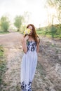 Red-haired young lady in floral dress with bouquet of daffodils Royalty Free Stock Photo