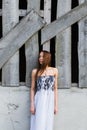 Red-haired young woman in floral dress near abandoned building Royalty Free Stock Photo