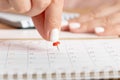 Beautiful female Hand with manicure pushes a red pin on a calendar 20 day Royalty Free Stock Photo