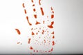 Red hand print on white dirty background. Concept of danger, Halloween. Bloody red trail hand. drops in shape of palm