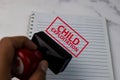 Red Handle Rubber Stamper and Child Exploitation text on White Background