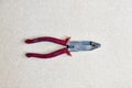 Red handled pliers on wood background