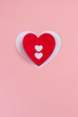 Red handmade paper heart on the pink background. Valentine`s or Wedding`s day postcard concept.