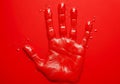 Red handprint on a red background with some drops of red paint around Royalty Free Stock Photo