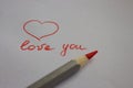 Red handwriting words love you with love heart and red pencil on white paper background. Valentine day concept. Royalty Free Stock Photo