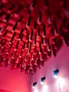 Vibrant red hanging installation creates dramatic lighting and abstract ceiling sculpture in contemporary space Royalty Free Stock Photo