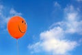 Red happy face balloon with blue sky athe background Royalty Free Stock Photo
