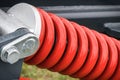 Red hard spring made of steel. Part of big industrial or agricultural machine Royalty Free Stock Photo