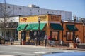 Red Hare Brewing and Distilling in an orange building with green awnings, tables and chairs on the sidewalk and people walking