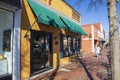 Red Hare Brewing and Distilling in an orange building with green awnings, tables and chairs on the sidewalk and people walking